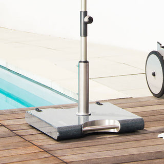 Ein Sonnenschirmständer mit Metallsockel am Pool auf einem Holzdeck.