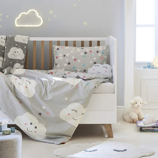 Kinderzimmer mit Kinderbett, Bettwäsche mit Wolkenmuster, einem Wolkennachtlicht, Sternentapete und Plüschtieren.