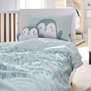 Kinderbett mit Bettwäsche und Kissen im Pinguin-Design.
