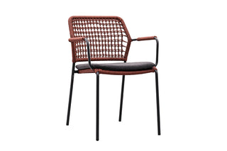 4Seasons Diningsessel Barista Terracotta: Ein moderner geflochtener Rattanstuhl mit schwarzen Metallbeinen, grauen Kissen und Armlehnen, ideal als Gartenmöbel.