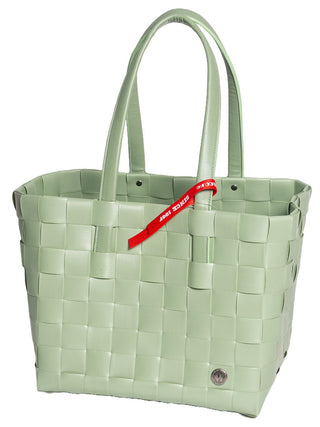 Der Witzgall Shopper 5050-48/0U Mint mit Lederhenkel ist eine hellgrüne gewebte Einkaufstasche aus robustem Material mit zwei Griffen und einem roten Etikett, die das klassische Design eines Witzgall Shoppers einfängt.