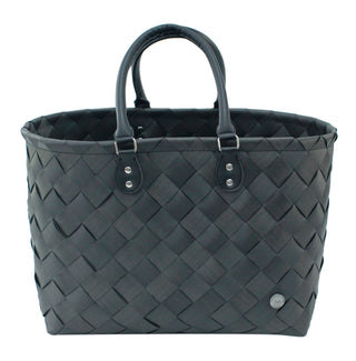 Die Witzgall Shopper Beach Bag 5600 von Witzgall ist eine schwarze gewebte Tragetasche mit zwei Griffen und einem kleinen runden Emblem in der unteren rechten Ecke, ideal für jeden Ausflug.