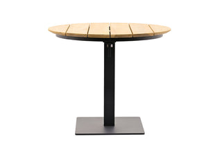 Der Best Tisch Cervia Ø90cm Teak/Anthrazit ist ein moderner Tisch mit einer runden Tischplatte aus Teakholz und einem schwarzen Metallsockel auf einem quadratischen Sockel aus wetterbeständigen Materialien.