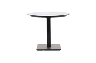 Der Bistrotisch Best Tisch Cervia Ø90 cm aus HPL/Alu verfügt über eine elegante weiße HPL-Platte und eine stabile schwarze Mittelsäule, die sich elegant vor einem schlichten Hintergrund präsentiert.