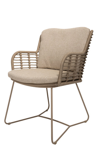 Der 4Seasons Dining-Stuhl Fabrice Latte, ein beigefarbener geflochtener Stuhl mit Metallbeinen und geschwungenen Armlehnen, eignet sich perfekt sowohl für Ess- als auch Gartenumgebungen und präsentiert sich elegant vor einem weißen Hintergrund.
