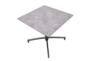 Der KETTLER Gartentisch Tube 80x80cm verfügt über eine graue HPL-Beton-Tischplatte und ein stabiles schwarzes Vierbein-Aluminiumgestell in Anthrazit.