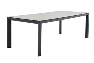 Der Lesli Living Gartentisch Mojito 220 x 100 cm verfügt über eine schlichte, rechteckige Tischplatte aus Glaskeramik mit einem dunklen, pulverbeschichteten Aluminiumrahmen.