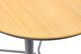 Nahaufnahme des Solpuri Bartisch Napoli Ø70cm, der seine strukturierte Teakholz-Tischplatte und Metallbeine zur Schau stellt, ideal für einen eleganten Außenbereich.
