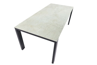 Der Sit Mobilia Auszugstisch Malta Tisch mit einer hellen Dekton-Tischplatte und schwarzen Edelstahlgestell-Beinen wird schräg vor einem weißen Hintergrund betrachtet.