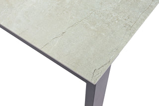Nahaufnahme eines Tisches, der den Sit Mobilia Auszugstisch Malta mit einer strukturierten hellgrauen Dekton-Oberfläche und dunklen, abgewinkelten Beinen präsentiert, der Eleganz und Haltbarkeit vereint.