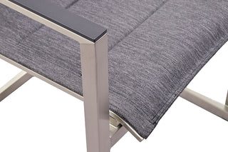 Nahaufnahme des Zeo Living Freischwinger Chelsea NL-Stuhls mit grauem Sitz mit Olefinstoff, glatten Armlehnen aus Metall und modernem Design.