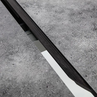 Nahaufnahme des Kettler Ausziehtischs 120/170x120cm von Kettler, mit einer HPL-Tischplatte aus Beton mit einer zentralen Öffnung, durch die ein reflektierender Metallstreifen darunter sichtbar wird.
